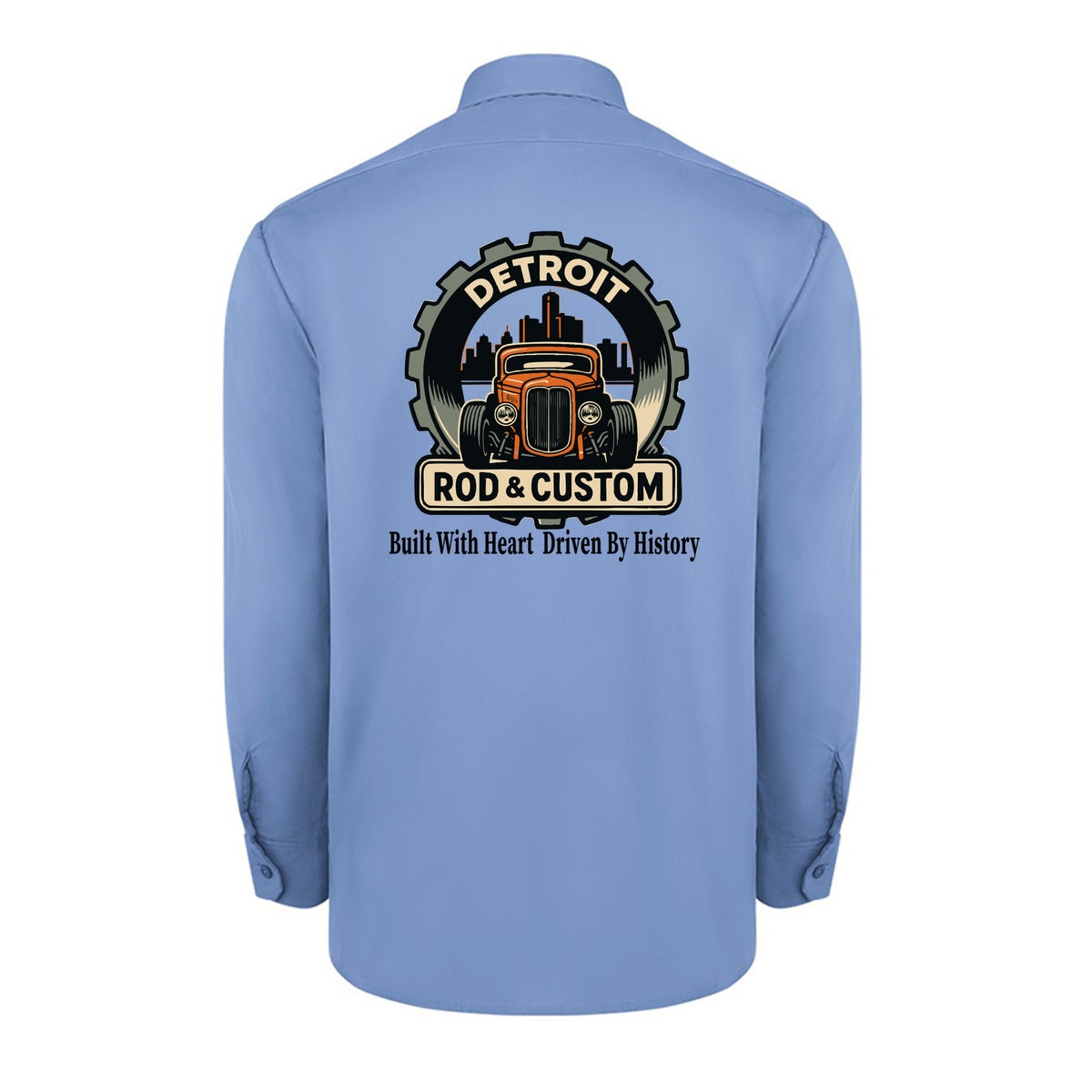 Back of a light blue Dickies long-sleeve work shirt with an orange hot rod coupe in a DETROIT ROD & CUSTOM gear badge over the Detroit skyline, with Built With Heart Driven By History below.