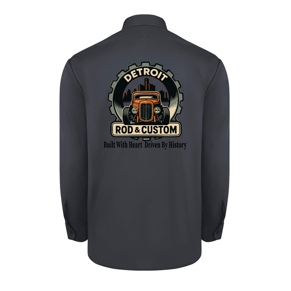Back of a dark charcoal Dickies long-sleeve work shirt with an orange hot rod coupe in a DETROIT ROD & CUSTOM gear badge over the Detroit skyline, with Built With Heart Driven By History below.