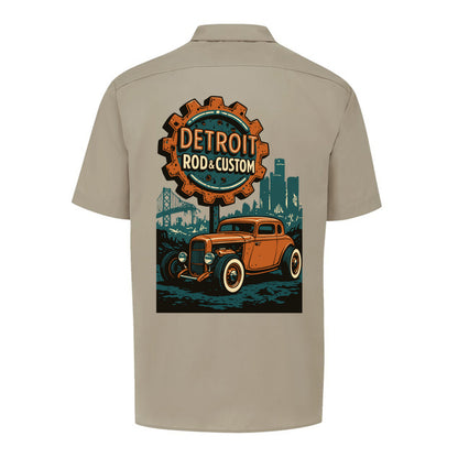 Back of a desert sand Dickies short-sleeve work shirt with an orange Atomic Coupe hot rod under a DETROIT ROD & CUSTOM gear badge.