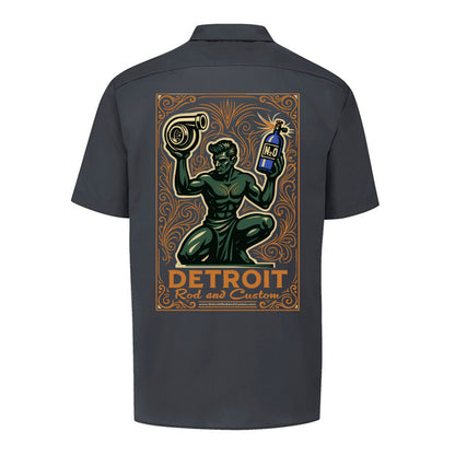Back of a dark charcoal Dickies work shirt with a large print of the green kneeling statue holding a turbo and a bottle, over an orange DETROIT Rod and Custom panel.