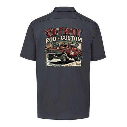 Back of a dark charcoal Dickies short-sleeve work shirt with a burgundy #58 Galaxie gasser launching nose-up under a red DETROIT ROD & CUSTOM banner.