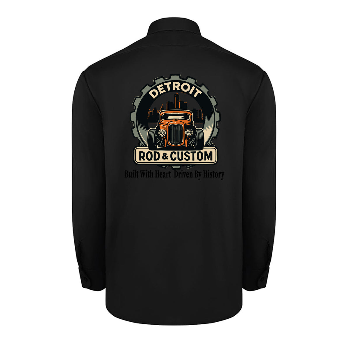 Back of a black Dickies long-sleeve work shirt with an orange hot rod coupe in a DETROIT ROD & CUSTOM gear badge over the Detroit skyline, with Built With Heart Driven By History below.